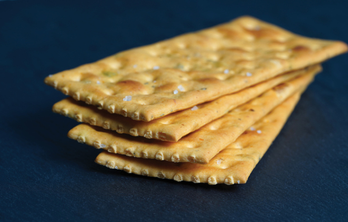 Stack of Delicious salty crackers isolated on black background - stock photo